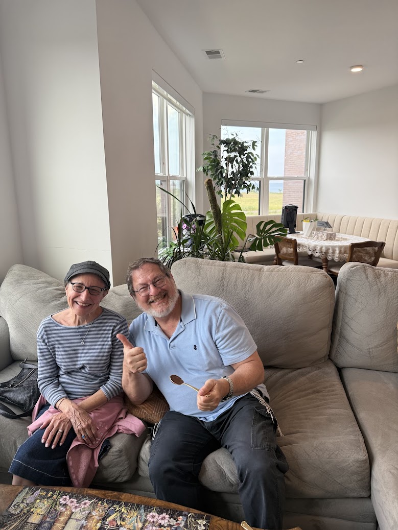 A smiling couple sitting together on a sofa