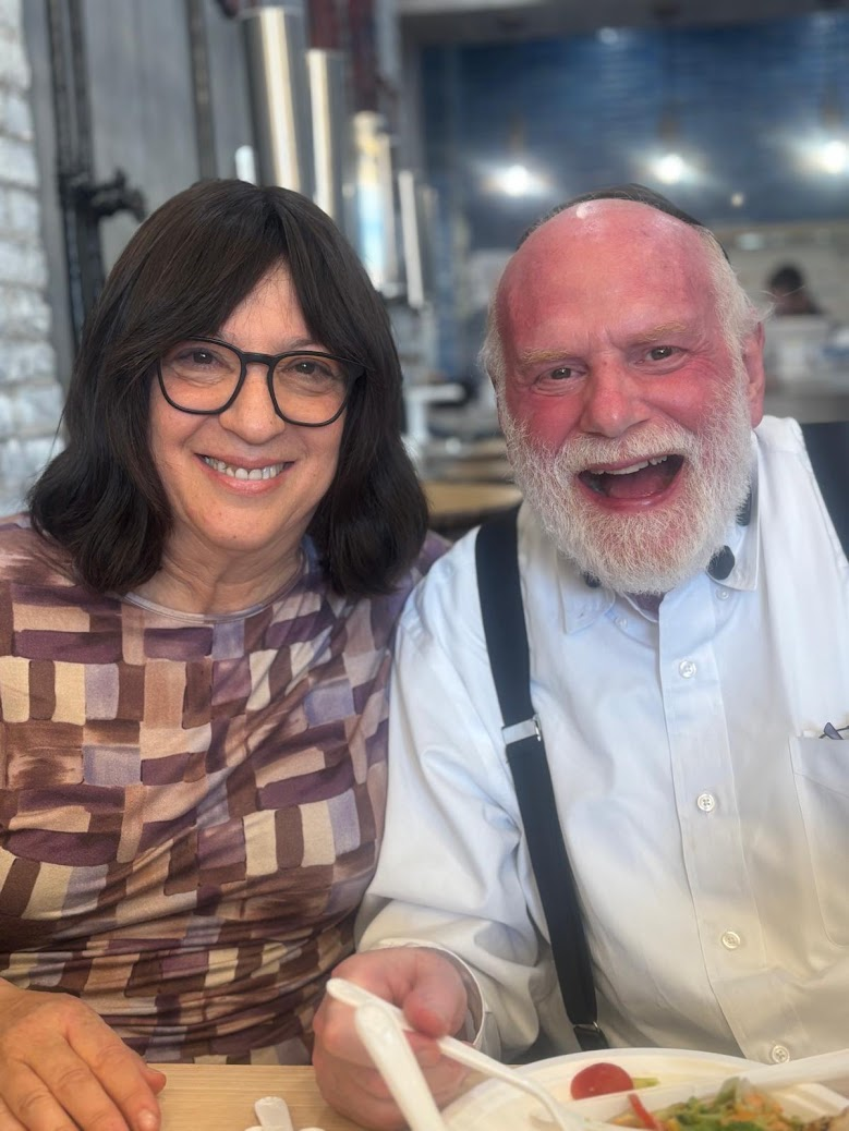 A smiling couple seated together at a restaurant